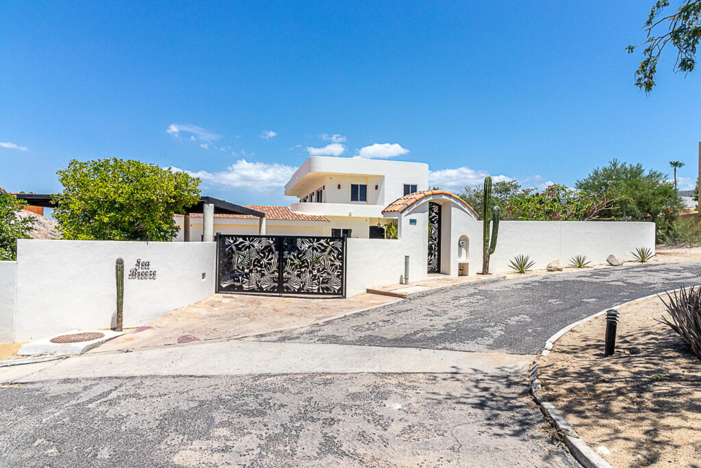 Los Cabos Las Tunas The Nacuii Residence is a refined luxury home crafted to exceed the expectations of even the most discerning buyer. Nestled on a generous and private 3,000 m² lot (0.73 acres), it's just a short, effortless stroll to the untouched, sandy shores of Las Tunas — perfect for enjoying the serene coastal landscape and dramatic sunsets. The home offers a thoughtful layout with 3 spacious bedrooms, a separate studio, a cozy TV lounge, and 6 full bathrooms, including two principal suites, a guest room, a detached studio, and a dedicated media or family room. Expansive sliding glass doors invite natural light throughout the interiors while showcasing tranquil garden – 148 PASEO DE LAS MISIONES, Cabo Corridor, BS